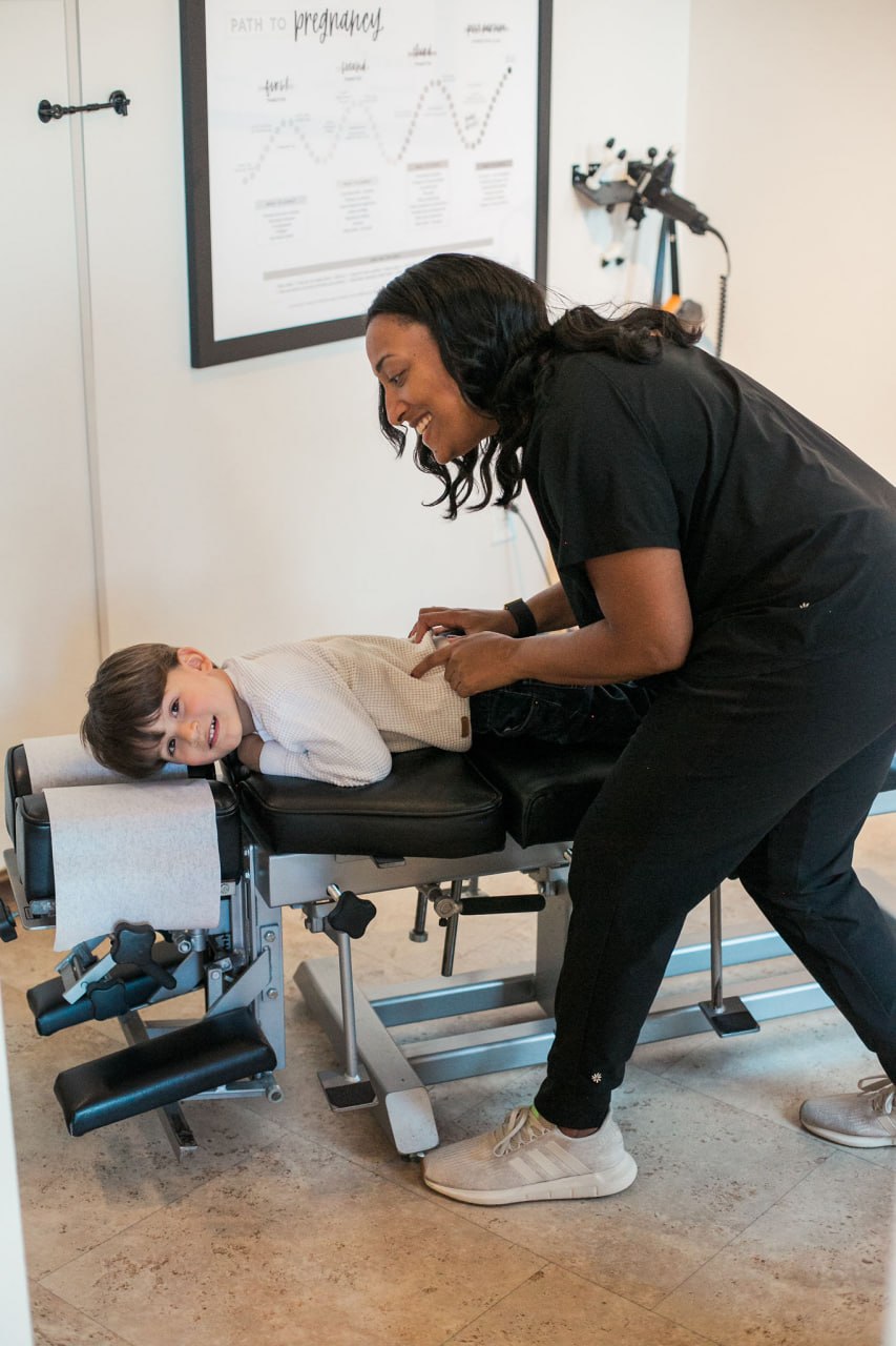 Doctor adjusting a child — pediatric chiropractic care